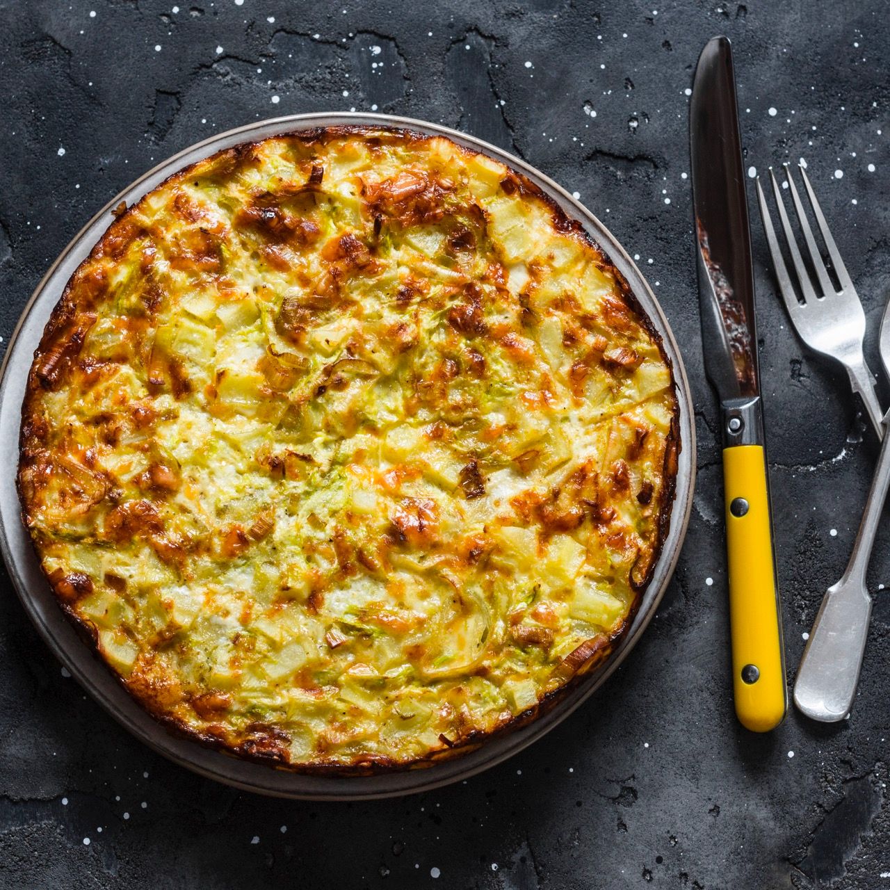 Leeks,-potatoes,-zucchini-tortilla-on-a-dark-background,-top-view.-Delicious-appetizer,-tapas,-breakfast-1192508640_4859x3593 squared Large.jpeg