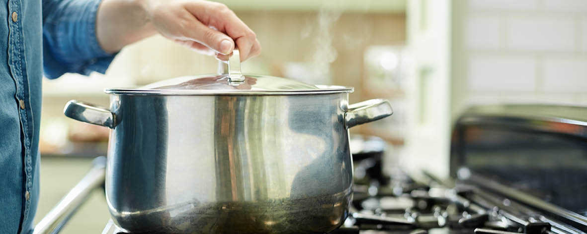 What is the benefit of putting a lid on top of a pan when cooking