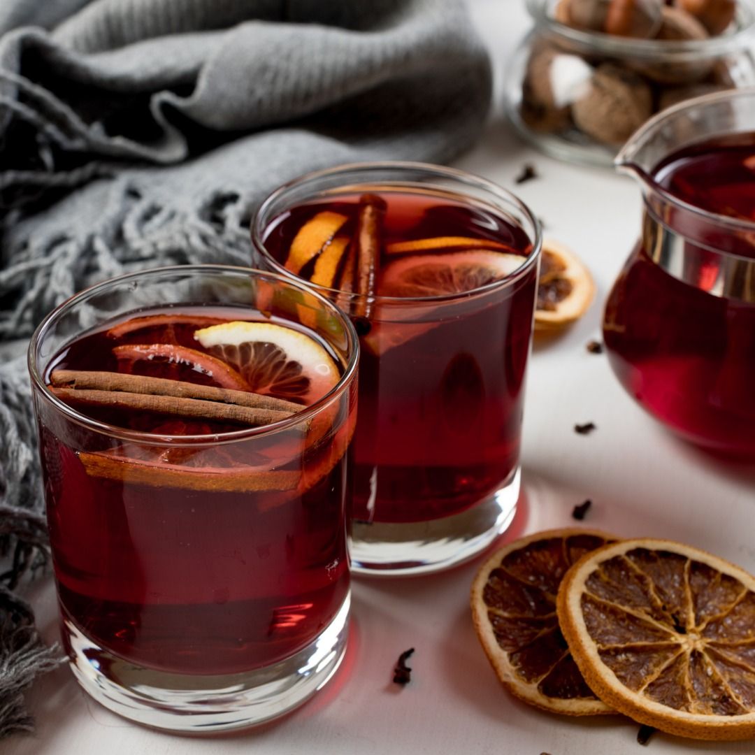mulled-wine-in-glasses-with-orange-and-spices-near-gray-scarf-picture-id1097499066.jpg