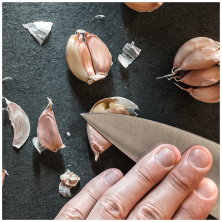 the next best trick is to place a clove on its side on a cutting board and press down hard with a large flat bladed knife